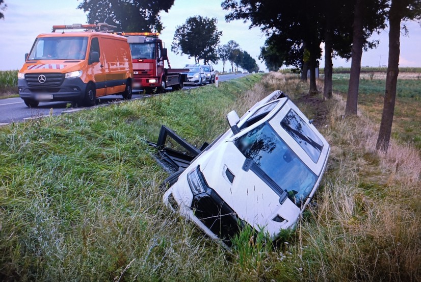 uszkodzone biało auto SUV w rowie w dzień latem